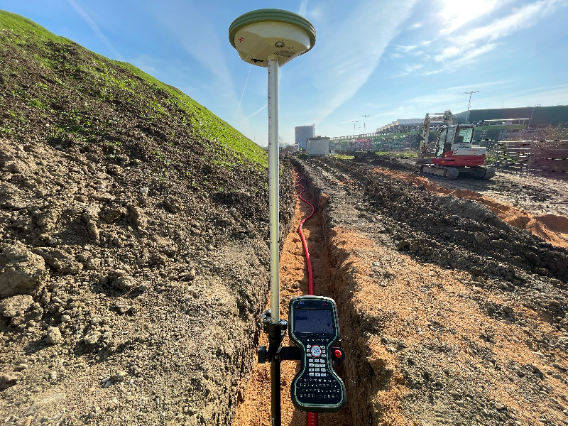 GNSS prijímač Geo-group na výtyčke s ovládacím kontrolérom pri zameraní v teréne. Dopĺňa sekciu o úlohe geodeta pri pozemkových úpravách.